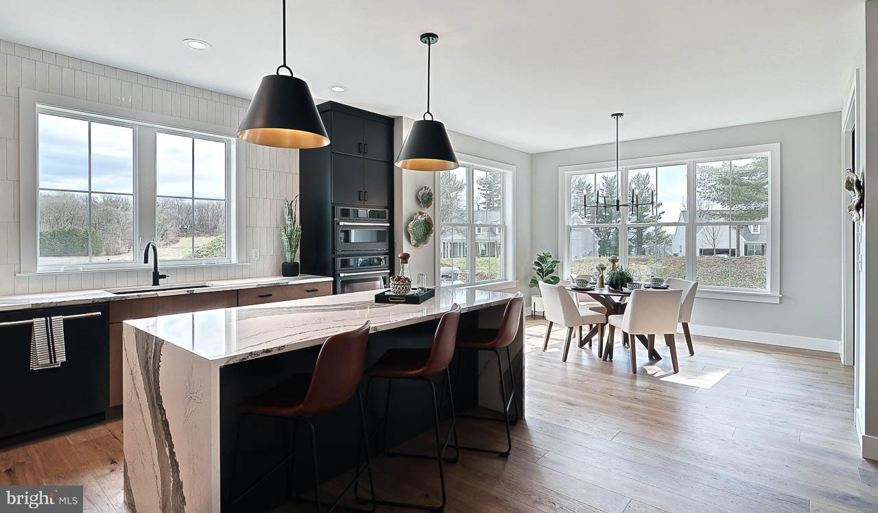 90 Tupelo Street Lititz, PA 17543 - Photo 16 of 38 a open kitchen with stainless steel appliances granite countertop a stove a refrigerator a sink a dining table and chairs with wooden floor