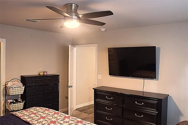 a living room with a dresser and a flat screen tv