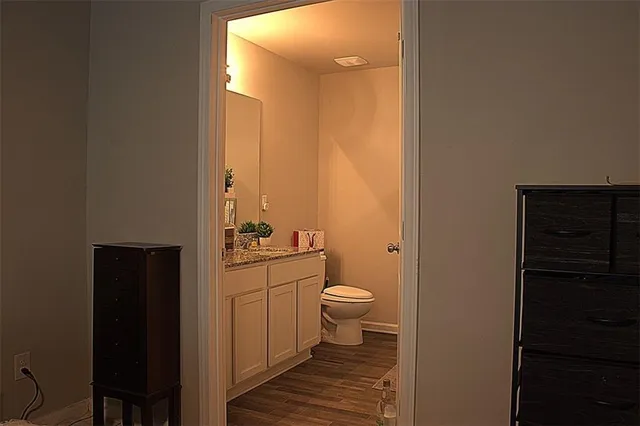 a bathroom with a granite countertop toilet a sink and a mirror