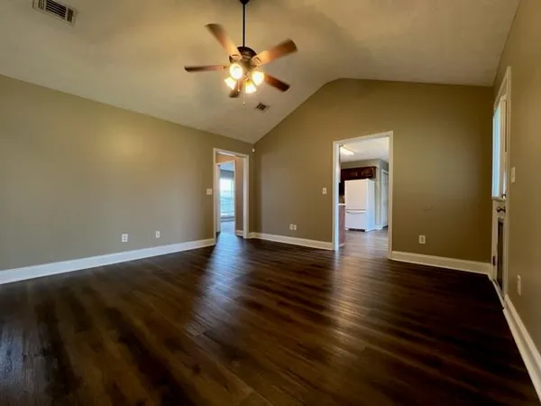 a view of an empty room with wooden floor