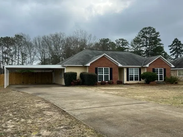a front view of a house with a yard and trees