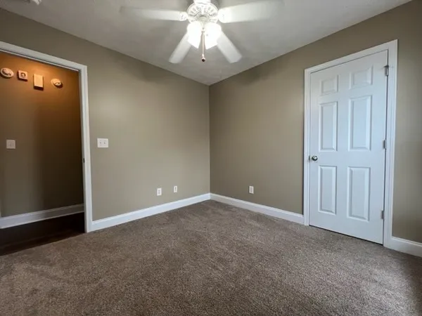 an empty room with chandelier fan