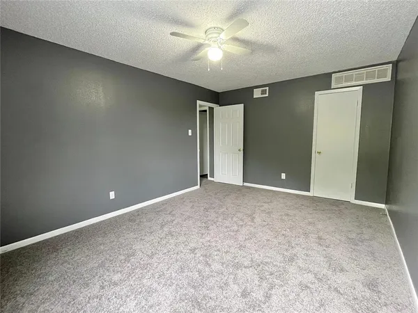 a view of a big room with a ceiling fan and a fan