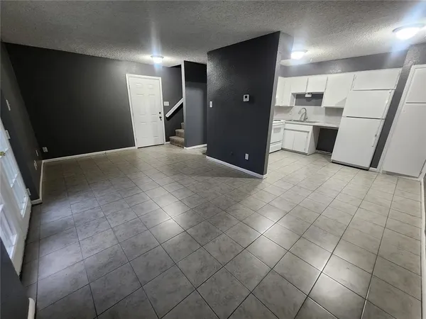 a view of a kitchen with white cabinets and refrigerator
