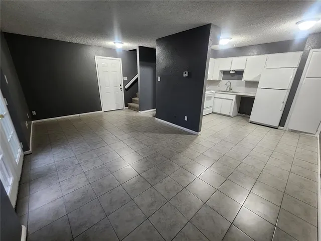 a view of a kitchen with white cabinets and refrigerator