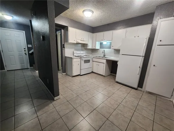 a kitchen with a refrigerator sink and cabinets