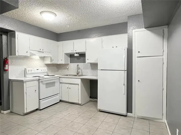 a kitchen with a refrigerator sink and cabinets