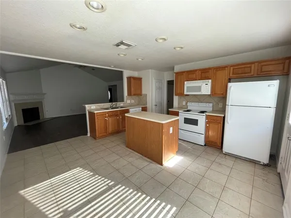 a kitchen with granite countertop a sink a counter top space stainless steel appliances and cabinets