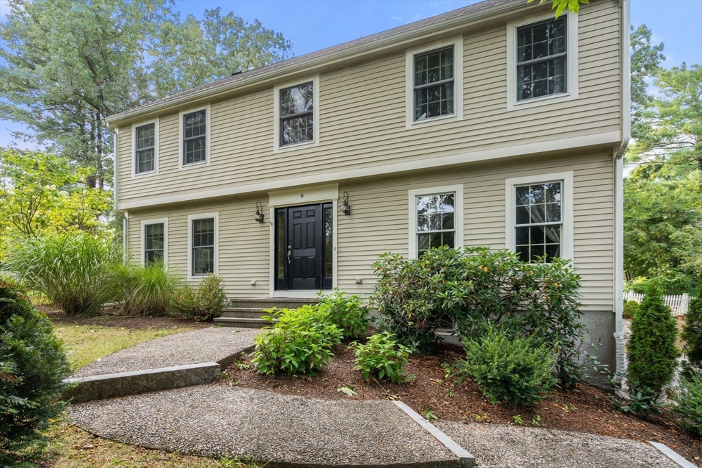 a front view of a house with garden and plants
