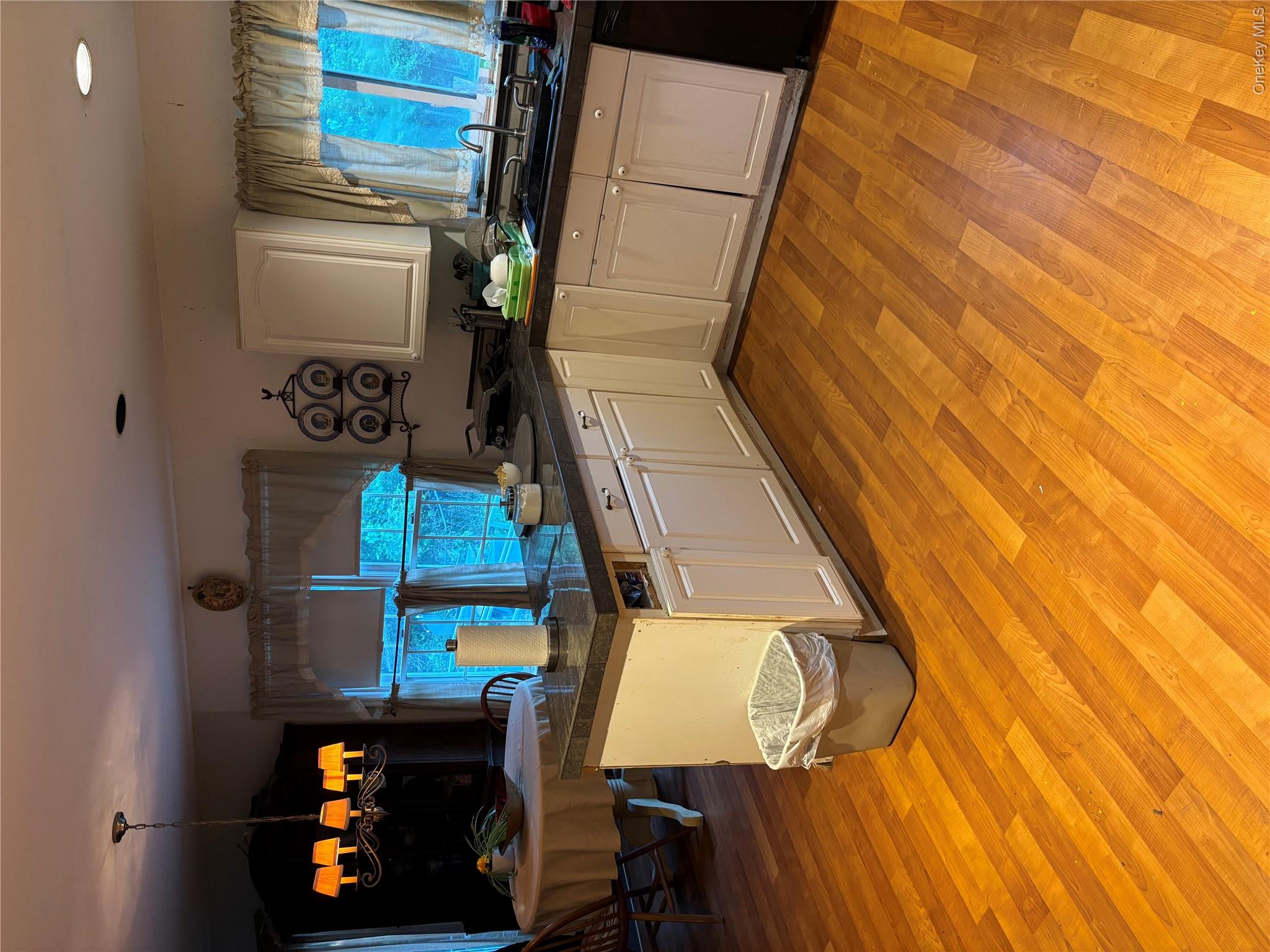 60 Randall Road Wading River, NY 11792 - Photo 2 of 14 Kitchen featuring a chandelier, white cabinetry, healthy amount of natural light, light wood-style floors, and recessed lighting