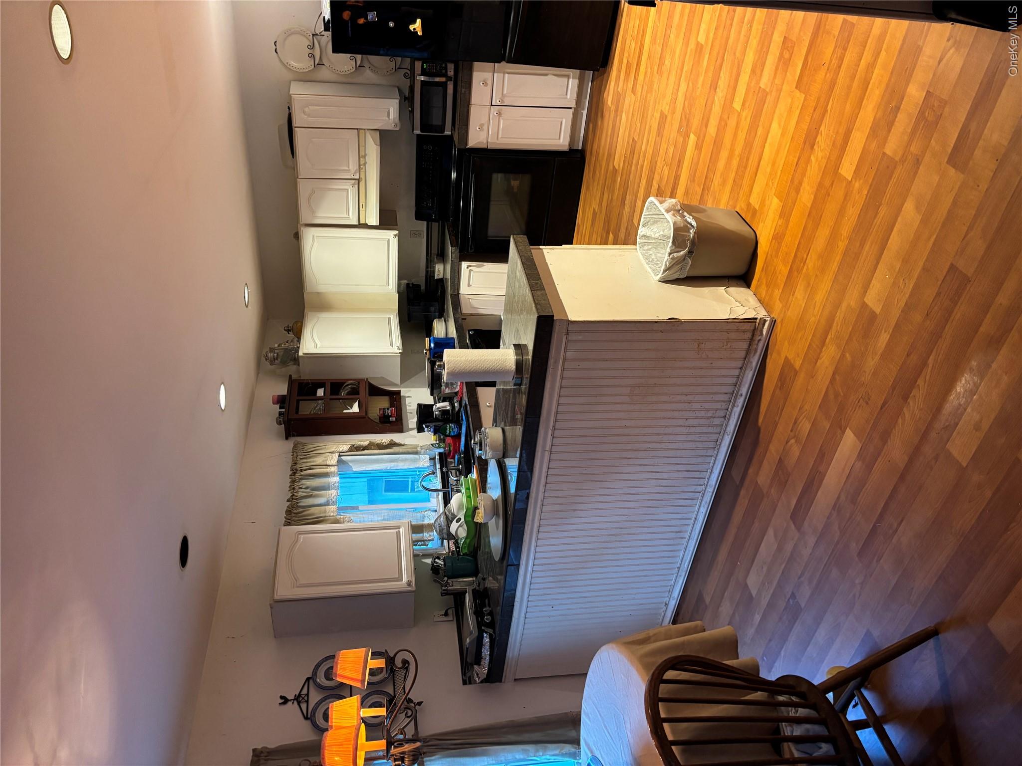 60 Randall Road Wading River, NY 11792 - Photo 3 of 14 Kitchen featuring dark countertops, stove, refrigerator, a peninsula, and white cabinets