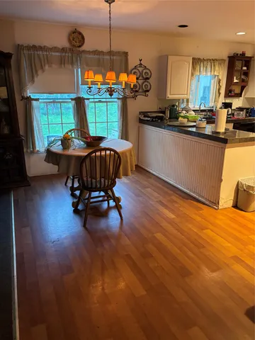 a kitchen with stainless steel appliances granite countertop a stove and a wooden floor
