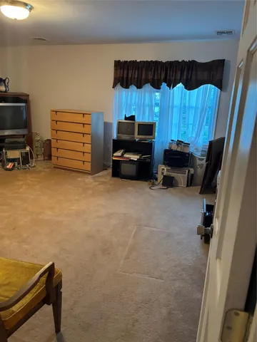 a view of a room with furniture and a flat screen tv