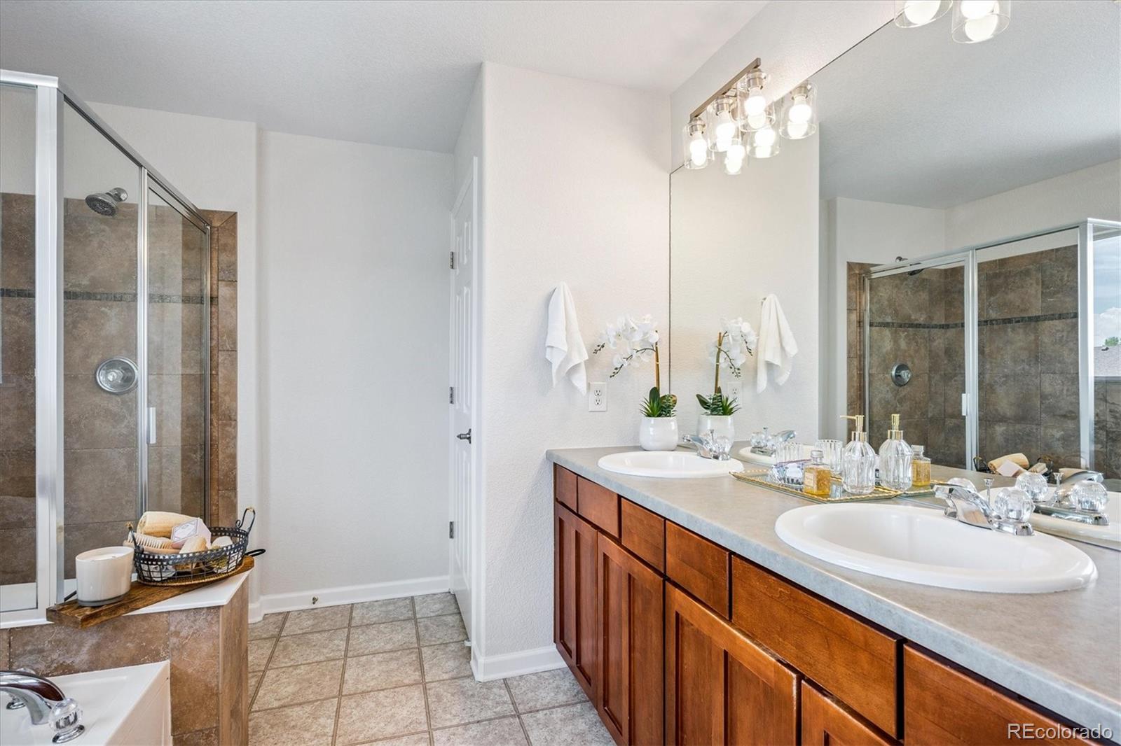 11815 Stuart Place Westminster, CO 80031 - Photo 22 of 36 a bathroom with a double vanity sink and a mirror