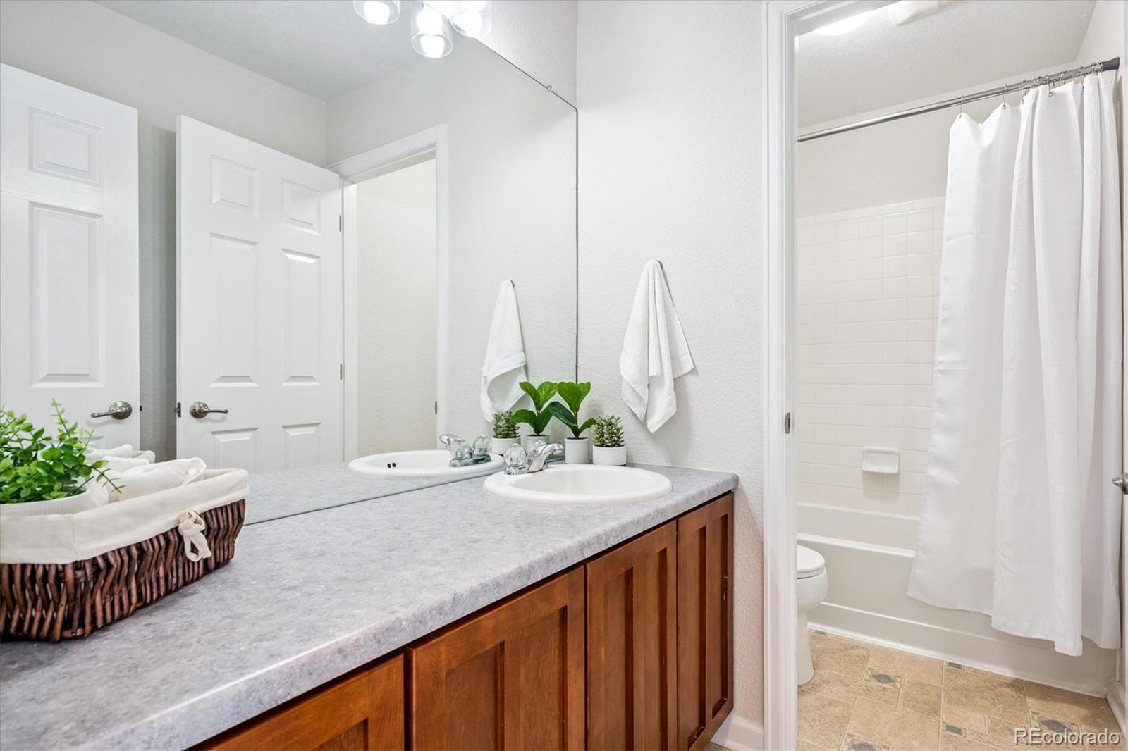 11815 Stuart Place Westminster, CO 80031 - Photo 25 of 36 a spacious bathroom with a double vanity sink and a bathtub