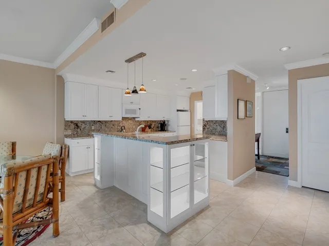 a kitchen with white cabinets and refrigerator