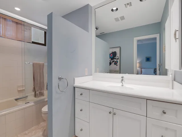 a en suite bathroom with a granite countertop sink and a mirror