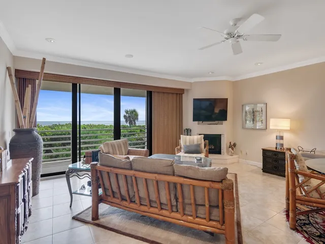 a living room with furniture a flat screen tv and a floor to ceiling window
