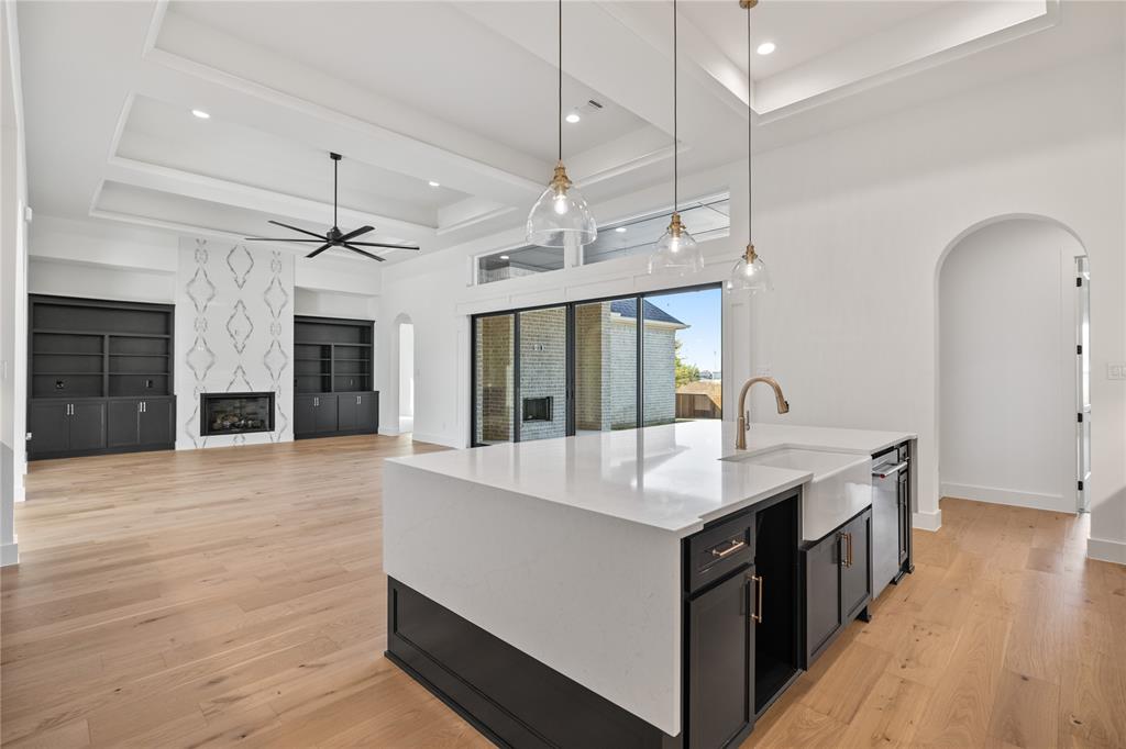 229 Bel Grand Road Haslet, TX 76052 - Photo 23 of 37 a large white kitchen with a large island oven a stove a sink and dishwasher with wooden floor