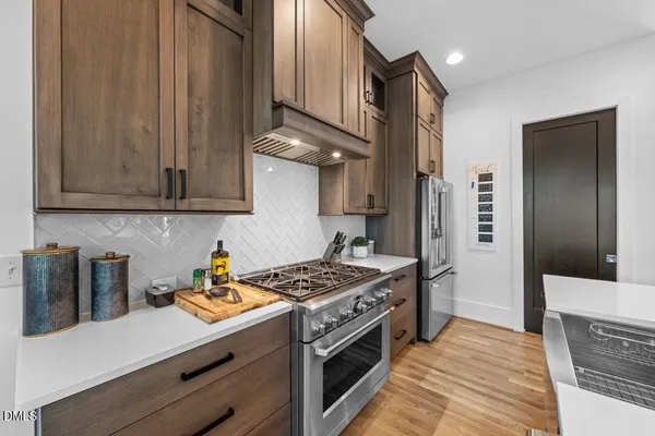 a kitchen with stainless steel appliances granite countertop a sink stove and refrigerator