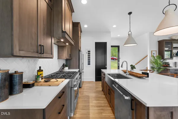 a kitchen with stainless steel appliances a stove oven and a wooden floor
