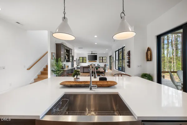 a kitchen with stainless steel appliances a dining table chairs stove refrigerator and cabinets