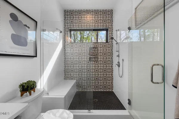 a bathroom with a sink a toilet a shower and a mirror