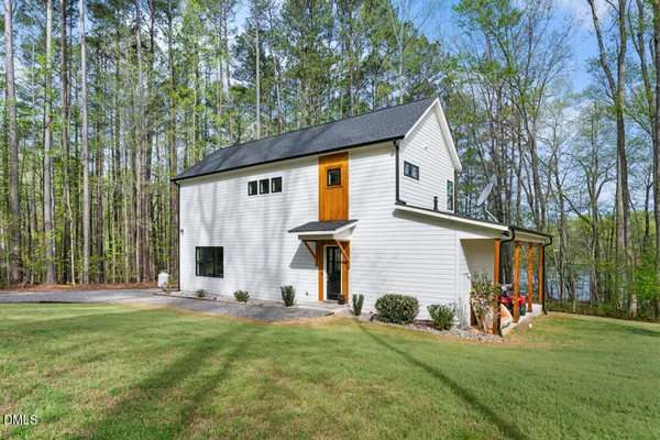 a view of a house with backyard and a tree