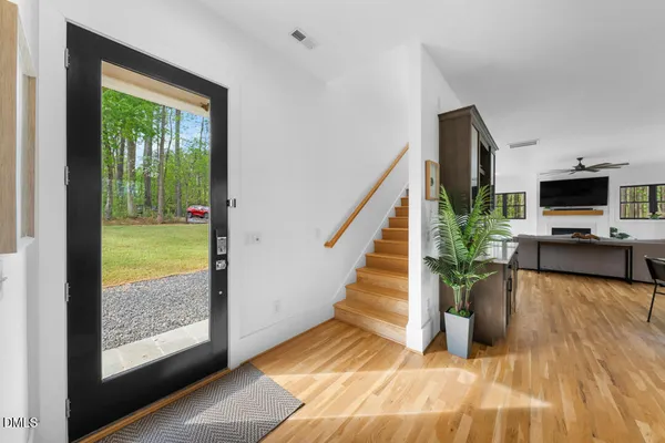 a kitchen with stainless steel appliances granite countertop a refrigerator a stove a sink dishwasher and a dining table with wooden floor