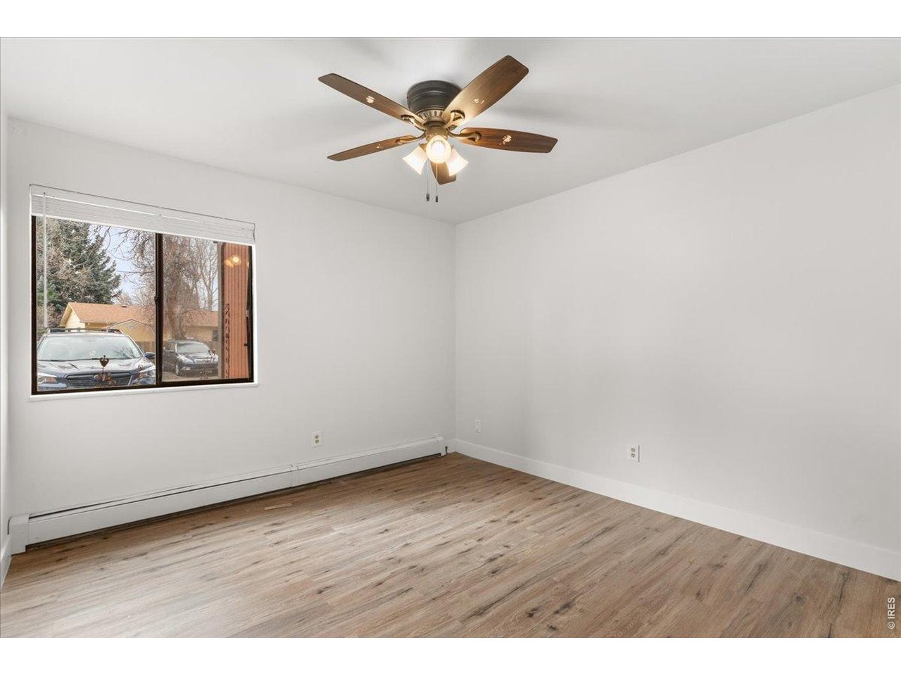 1625 West Elizabeth Street, Unit 2 Fort Collins, CO 80521 - Photo 18 of 29 an empty room with wooden floor and ceiling fan