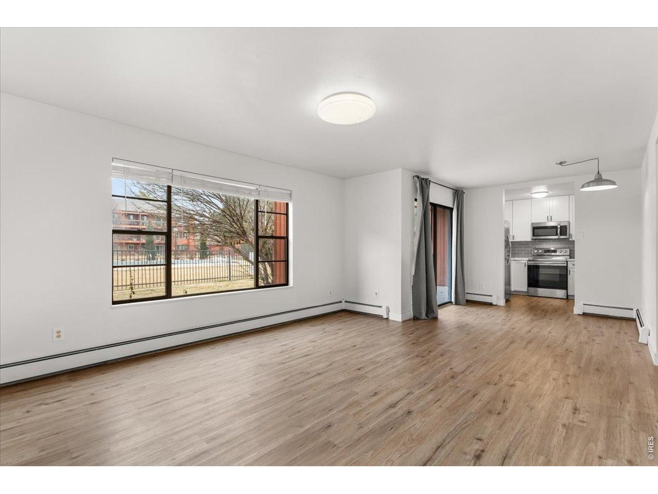 1625 West Elizabeth Street, Unit 2 Fort Collins, CO 80521 - Photo 6 of 29 a view of an empty room with a window and wooden floor