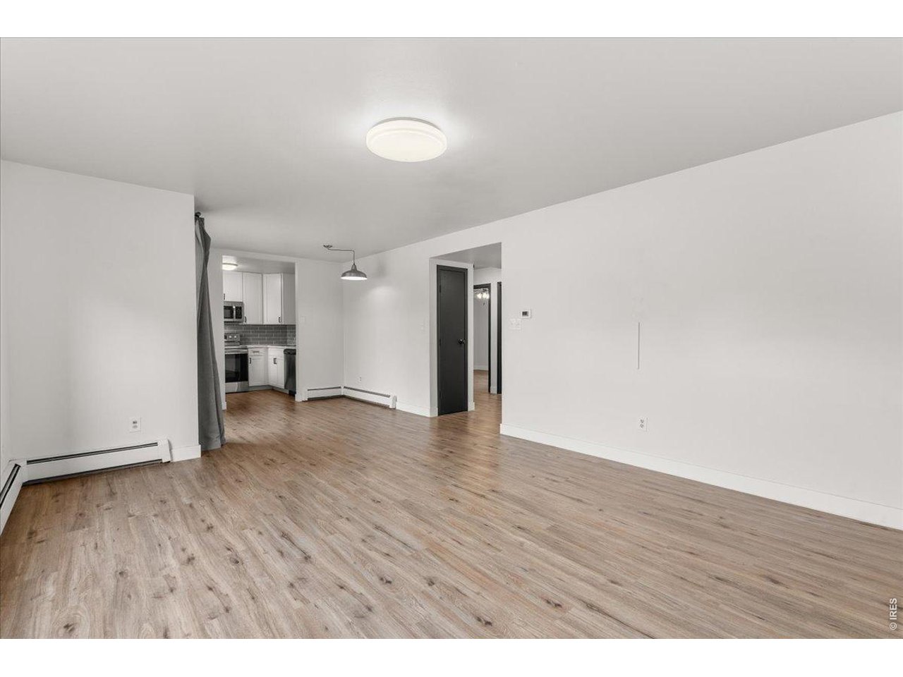 1625 West Elizabeth Street, Unit 2 Fort Collins, CO 80521 - Photo 7 of 29 a view of an empty room with wooden floor and a window
