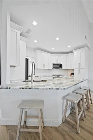 a kitchen with a table chairs stove and cabinets