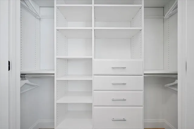 a view of walk in closet with empty racks