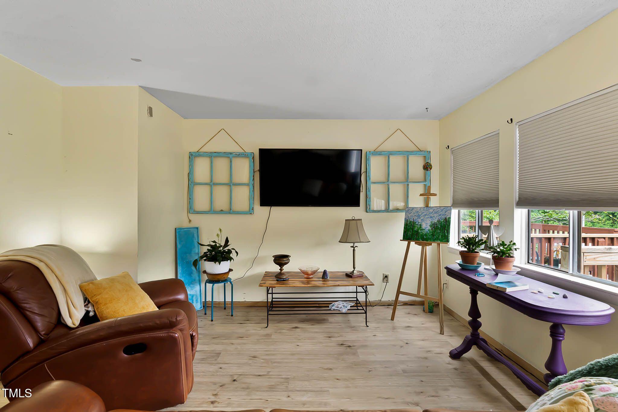 5931 Farm Gate Road Raleigh, NC 27606 - Photo 13 of 37 a living room with furniture and a flat screen tv