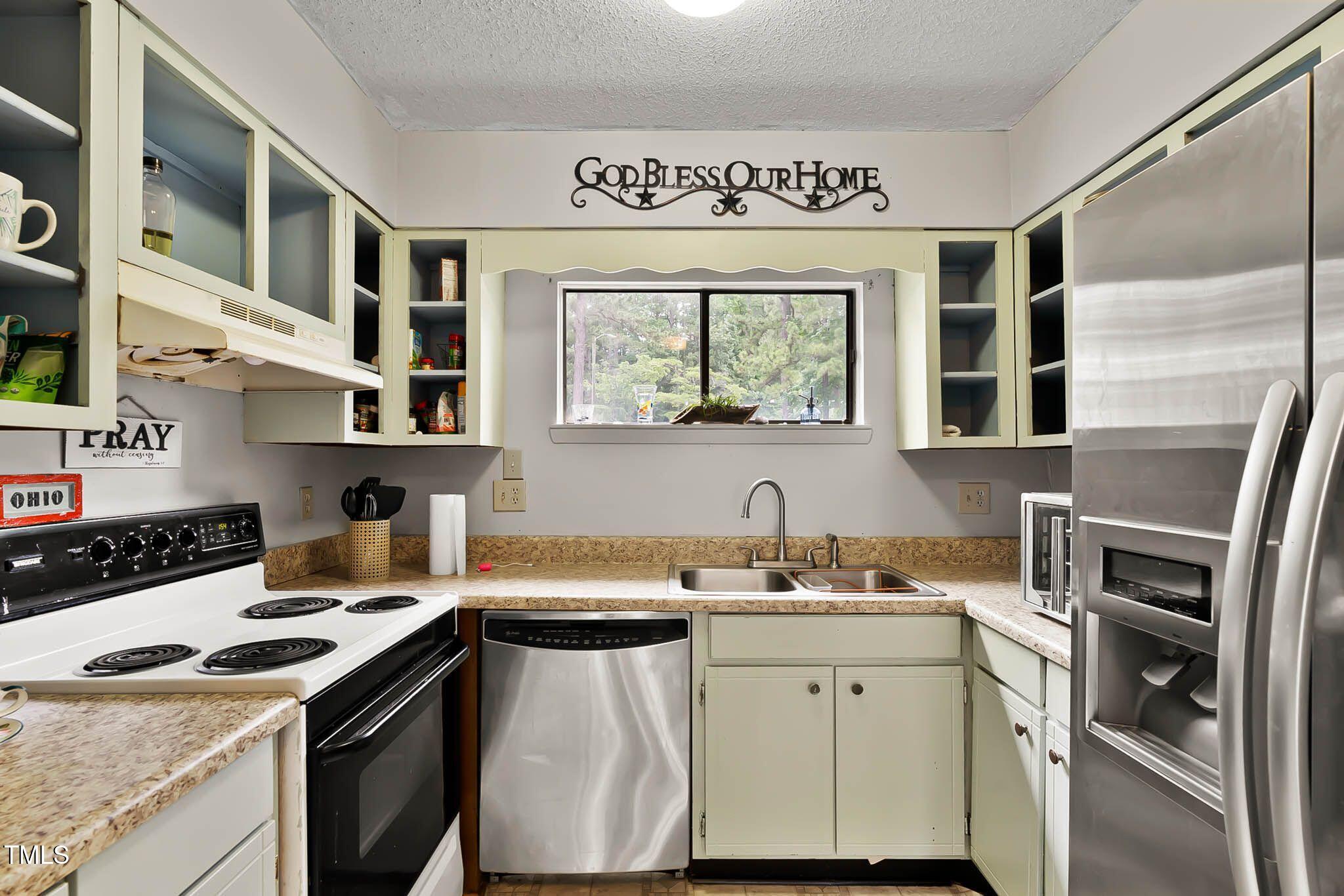 5931 Farm Gate Road Raleigh, NC 27606 - Photo 17 of 37 a kitchen with a sink stove and cabinets