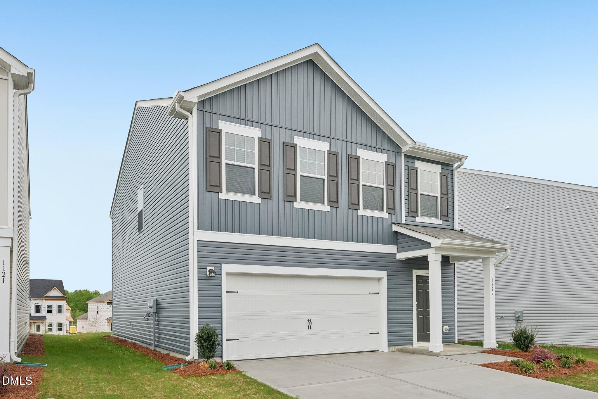 1345 Solace Way Rolesville, NC 27571 - Photo 2 of 24 a front view of a house with a yard and garage