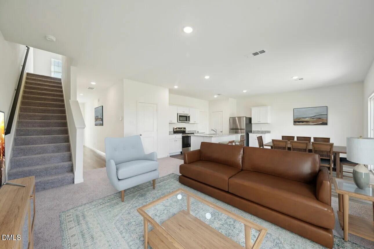 1345 Solace Way Rolesville, NC 27571 - Photo 5 of 24 a view of a living room a couch and a potted plant