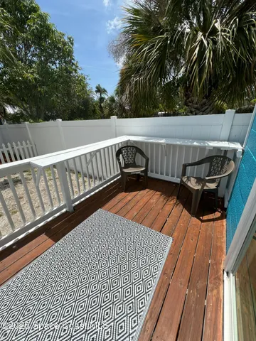 a view of balcony with wooden floor and seating space