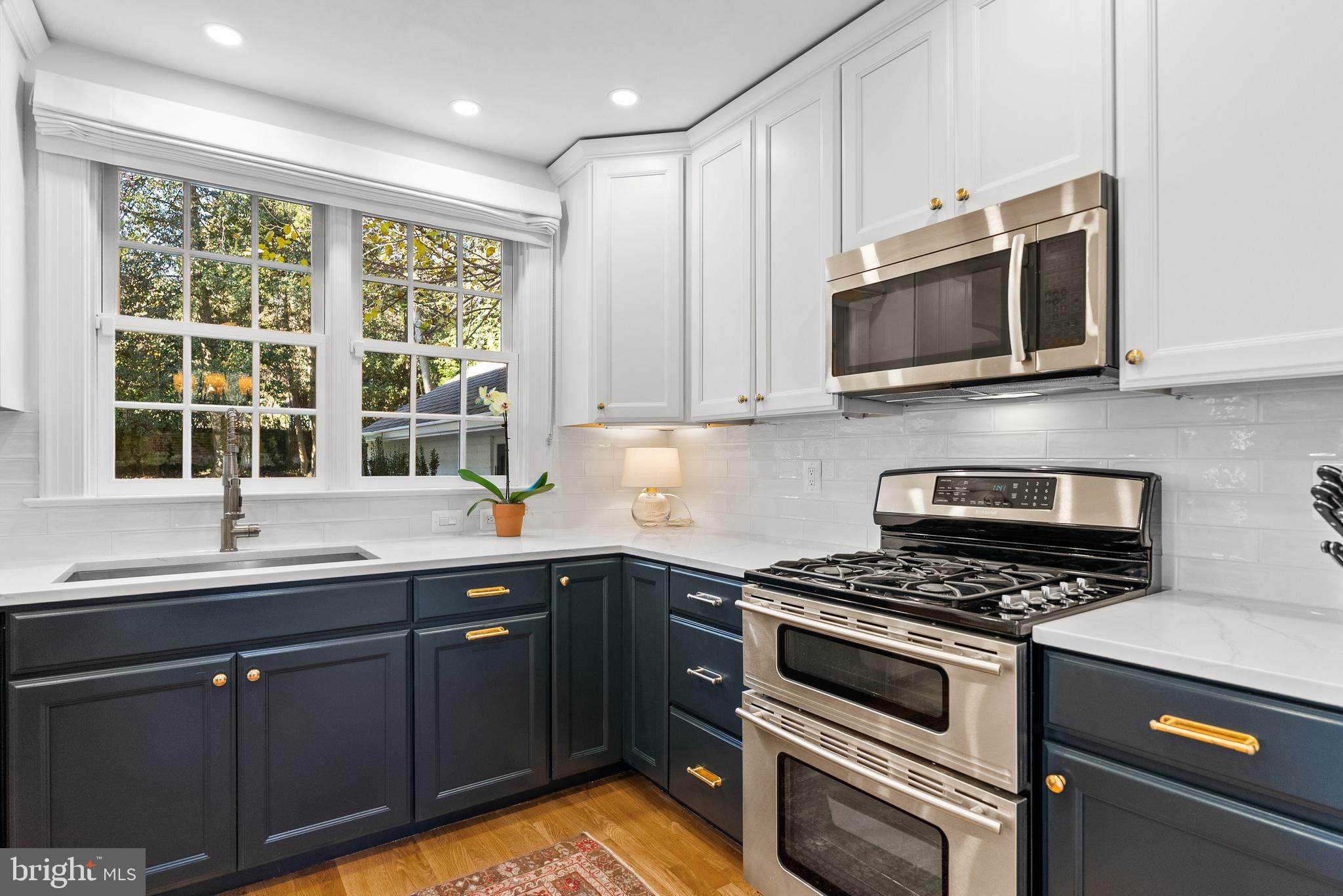 6032 Fort Hunt Road Alexandria, VA 22307 - Photo 18 of 49 a kitchen with stainless steel appliances granite countertop a sink a stove a microwave and wooden cabinets