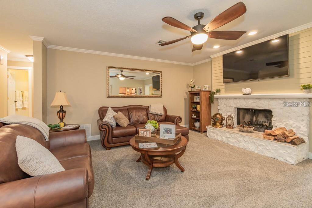 3341 Southeast 45th Street Ocala, FL 34480 - Photo 12 of 50 a living room with furniture a flat screen tv and a fireplace