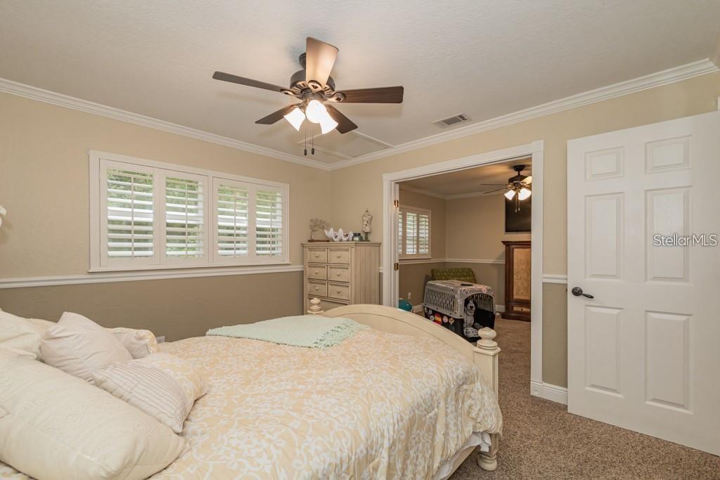 3341 Southeast 45th Street Ocala, FL 34480 - Photo 22 of 50 a bedroom with a bed and a chandelier