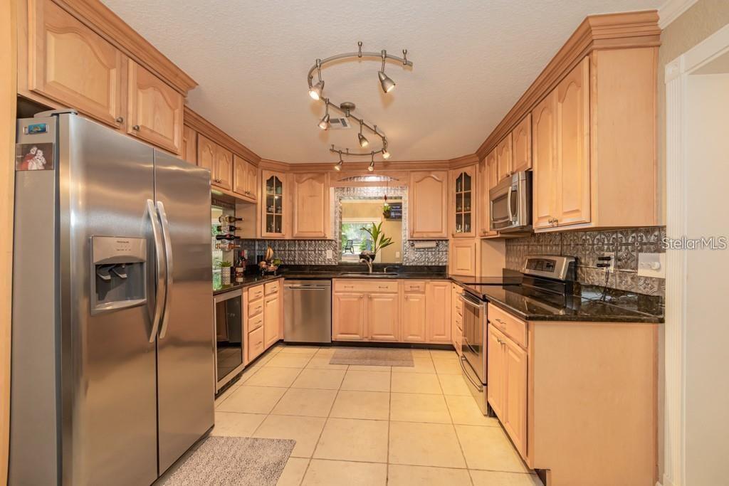3341 Southeast 45th Street Ocala, FL 34480 - Photo 6 of 50 a kitchen with stainless steel appliances granite countertop a refrigerator a sink dishwasher a stove with white cabinets