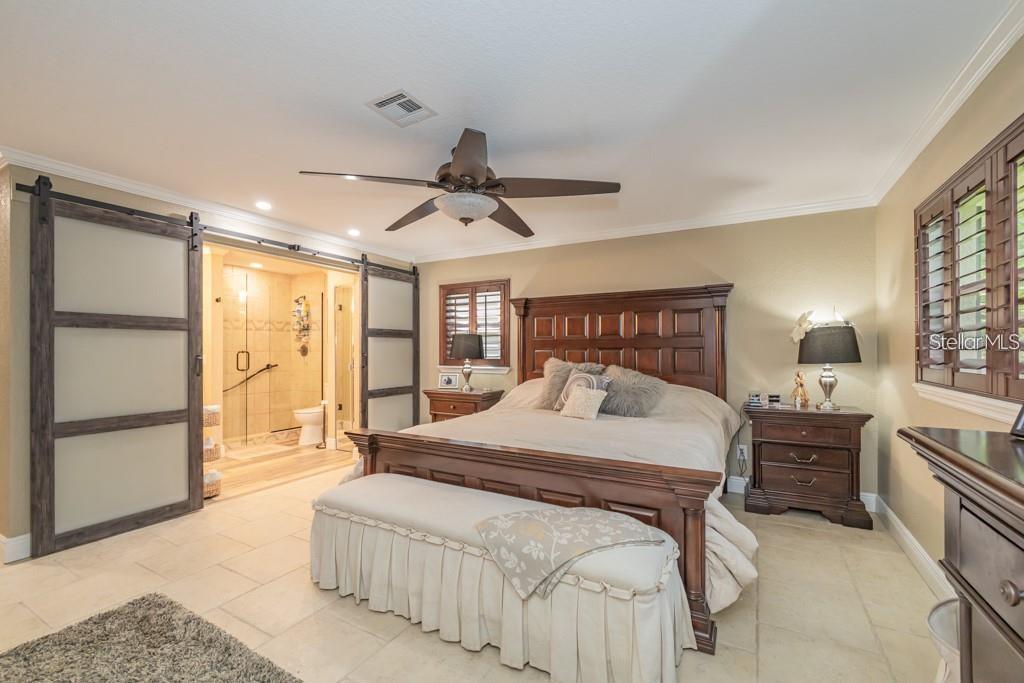 3341 Southeast 45th Street Ocala, FL 34480 - Photo 8 of 50 a bedroom with a large bed and a chandelier