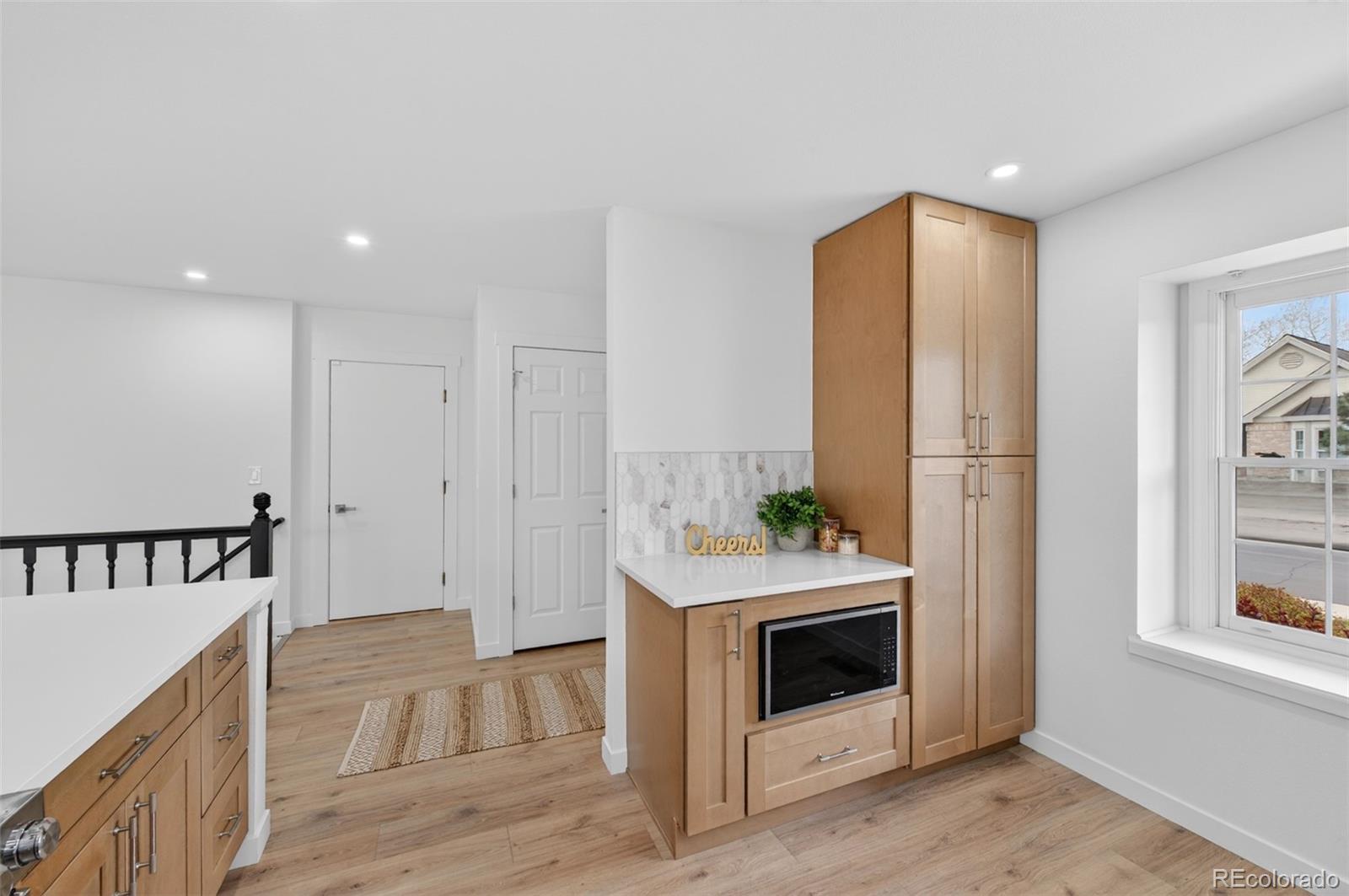 8943 Greenspointe Lane Highlands Ranch, CO 80130 - Photo 29 of 38 a hallway with cabinets and wooden floor