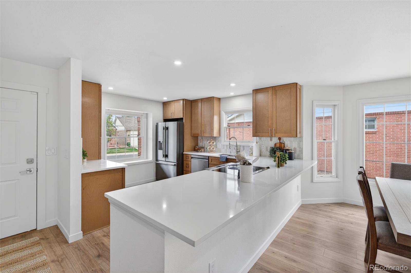 8943 Greenspointe Lane Highlands Ranch, CO 80130 - Photo 3 of 38 a view of a kitchen with kitchen island a dining table chairs stainless steel appliances and cabinets
