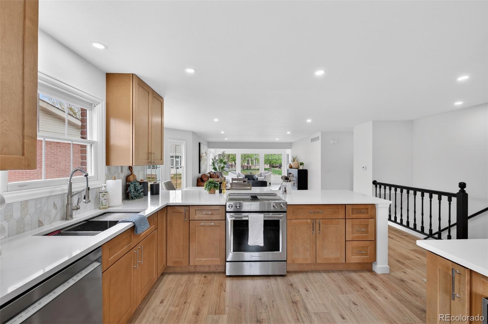 8943 Greenspointe Lane Highlands Ranch, CO 80130 - Photo 4 of 38 a large kitchen with stainless steel appliances a lot of counter space and a wooden floors