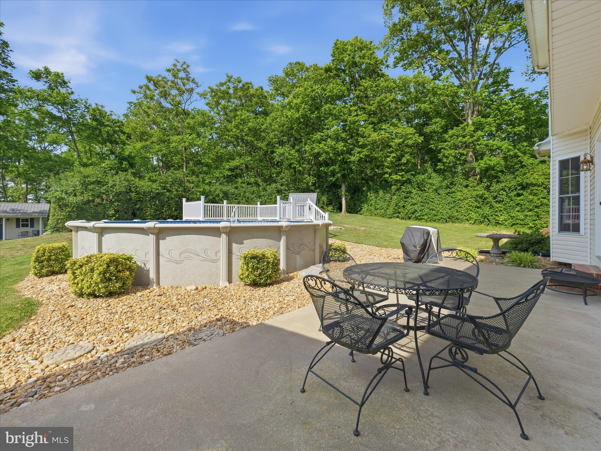 726 Doe Run Road Inwood, WV 25428 - Photo 12 of 68 a view of backyard with seating space and trees in the background