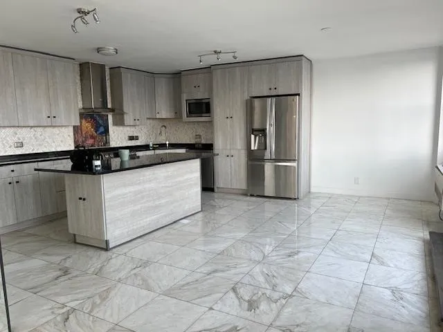 a kitchen with stainless steel appliances granite countertop a stove a refrigerator a sink a microwave and island