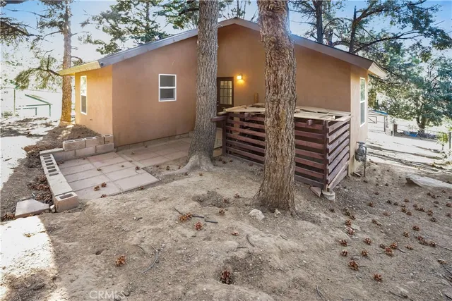a view of house with backyard and trees